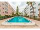 Outdoor swimming pool surrounded by brick pavers and community buildings at 5501 80Th N St # 206, St Petersburg, FL 33709