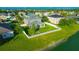 Aerial view of fenced backyard with a fire pit and a large pond with other houses at 5624 Fisher Glen Loop, Wesley Chapel, FL 33545
