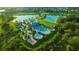 Wide aerial view shows community pools, playground, and lakes amidst lush landscaping in residential area at 5624 Fisher Glen Loop, Wesley Chapel, FL 33545