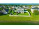 Aerial view showcases a fenced backyard with fire pit and a large pond at 5624 Fisher Glen Loop, Wesley Chapel, FL 33545