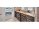 Bathroom featuring double granite vanity sinks and a view into an adjacent bedroom at 5624 Fisher Glen Loop, Wesley Chapel, FL 33545