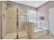 Bathroom showcasing glass-enclosed shower and soaking tub with a window view at 5624 Fisher Glen Loop, Wesley Chapel, FL 33545