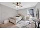 Cozy bedroom featuring a ceiling fan, a plush bed, and a bright window for natural light at 5624 Fisher Glen Loop, Wesley Chapel, FL 33545