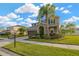 Charming two-story home featuring a well-manicured lawn, lush landscaping, and a welcoming front porch at 5624 Fisher Glen Loop, Wesley Chapel, FL 33545