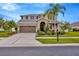 Charming two-story home featuring a well-manicured lawn, a two car garage, and a cozy front porch at 5624 Fisher Glen Loop, Wesley Chapel, FL 33545