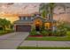Charming two-story home featuring a well-manicured lawn, a two car garage, and a cozy front porch at 5624 Fisher Glen Loop, Wesley Chapel, FL 33545