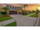 Charming two-story home featuring an attached two-car garage and beautiful landscaping, set at dusk at 5624 Fisher Glen Loop, Wesley Chapel, FL 33545