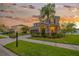 Beautiful two-story home with a well-manicured lawn and mature landscaping at sunset at 5624 Fisher Glen Loop, Wesley Chapel, FL 33545