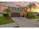 Stunning home with a well-kept lawn and lush landscaping that enhances its curb appeal, set at sunset at 5624 Fisher Glen Loop, Wesley Chapel, FL 33545