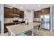 Bright kitchen with stainless steel appliances, granite counters, and dark wood cabinetry at 5624 Fisher Glen Loop, Wesley Chapel, FL 33545