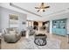 Open-concept living room with a tray ceiling, fireplace, and views into the kitchen at 5624 Fisher Glen Loop, Wesley Chapel, FL 33545