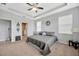 Relaxing main bedroom featuring tray ceilings, carpet floors and a ceiling fan at 5624 Fisher Glen Loop, Wesley Chapel, FL 33545