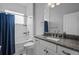 Bathroom featuring a shower/tub combination with blue shower curtain and granite vanity countertop at 5742 Stockport St, Riverview, FL 33578