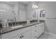 Bathroom featuring dual sinks with granite countertop and a frameless glass shower with chrome fixtures at 5742 Stockport St, Riverview, FL 33578