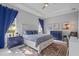 Bright bedroom featuring a white bed frame, blue accents and curtains, and tray ceiling with fan at 5742 Stockport St, Riverview, FL 33578