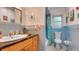 Bright blue bathroom with vanity sink, shower, and quirky flamingo towel rack at 6011 Tangerine S Ave, Gulfport, FL 33707