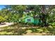 Landscaped front yard with mature trees and greenery surrounds the lovely single-story home at 6011 Tangerine S Ave, Gulfport, FL 33707