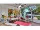Cozy sunroom featuring screened-in windows, wicker furniture, and brick paver flooring at 6011 Tangerine S Ave, Gulfport, FL 33707