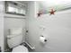 A cozy bathroom featuring a toilet, decorative mirror, and a window with starfish decor at 614 12Th Nw St, Largo, FL 33770
