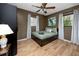 Well-lit bedroom with a ceiling fan, laminate wood flooring, and calming green bedding at 614 12Th Nw St, Largo, FL 33770