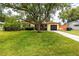 Charming single-story home with lush green lawn and mature trees at 614 12Th Nw St, Largo, FL 33770