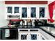 Galley kitchen featuring updated cabinets, a black countertop and updated appliances at 614 12Th Nw St, Largo, FL 33770
