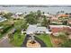 An aerial view of a single-story home with a well-manicured lawn, circular driveway, and waterfront views at 6913 Grande Vista S Way, St Petersburg, FL 33707