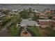 An aerial view of a single-story home with a well-manicured lawn, circular driveway, and waterfront views at 6913 Grande Vista S Way, St Petersburg, FL 33707