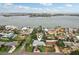 An aerial view of a single-story home with a well-manicured lawn, circular driveway, and waterfront views at 6913 Grande Vista S Way, St Petersburg, FL 33707