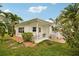 Backyard featuring tropical plants, landscaping, a covered patio, and a white exterior at 6913 Grande Vista S Way, St Petersburg, FL 33707