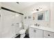 Bright bathroom features white cabinets, stylish mirror, black hardware, and updated shower at 6913 Grande Vista S Way, St Petersburg, FL 33707