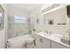 All white bathroom features marble accent tiles in shower and modern vanity at 6913 Grande Vista S Way, St Petersburg, FL 33707