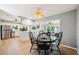 Open dining area with wood floors, a modern ceiling fan, and views to the kitchen and living room at 6913 Grande Vista S Way, St Petersburg, FL 33707