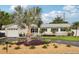 Well-maintained home featuring stone accents, lush landscaping, a circular driveway, and a two-car garage at 6913 Grande Vista S Way, St Petersburg, FL 33707