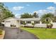 Charming single-story home boasts a well-manicured lawn and beautifully landscaped front yard with palm trees at 6913 Grande Vista S Way, St Petersburg, FL 33707
