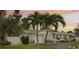 Charming home with stone accents, palm trees, manicured lawn, driveway, and an attached two-car garage at 6913 Grande Vista S Way, St Petersburg, FL 33707