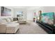 Open living room featuring a comfortable sectional sofa, neutral carpet, and a large window at 6913 Grande Vista S Way, St Petersburg, FL 33707
