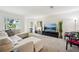 Spacious living room with neutral decor, large sectional, and a modern television setup at 6913 Grande Vista S Way, St Petersburg, FL 33707