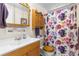 Bathroom featuring a vanity, commode, wooden cabinet, and a shower with a colorful floral curtain at 7118 El Meyers St, Zephyrhills, FL 33541