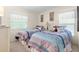 Bright bedroom featuring two twin beds with patterned bedding, framed artwork, and ample natural light at 7118 El Meyers St, Zephyrhills, FL 33541