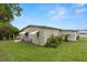 Charming single-story home with a well-maintained lawn, mature landscaping, and an AC unit at 7118 El Meyers St, Zephyrhills, FL 33541