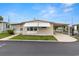 Inviting single-story home with awnings, a covered carport, and a manicured lawn at 7118 El Meyers St, Zephyrhills, FL 33541