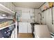 Functional laundry area with washer, dryer, shelving, and storage space for cleaning supplies at 7118 El Meyers St, Zephyrhills, FL 33541
