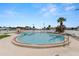 Large community pool with clear blue water, surrounding patio, lounge chairs, and palm trees at 7118 El Meyers St, Zephyrhills, FL 33541
