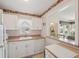 Functional kitchen with a modern dishwasher, white cabinets, and a window view to the neighborhood at 7304 W Country Club N Dr # 113, Sarasota, FL 34243