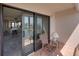 Sliding glass door opens to the tiled balcony with a chair and lamp perfect for relaxing at 7600 Sun Island S Dr # 603, South Pasadena, FL 33707