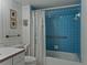 This bathroom features blue tiled shower with a white curtain, toilet and vanity with storage at 7600 Sun Island S Dr # 603, South Pasadena, FL 33707