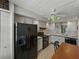 Kitchen with black refrigerator, white cabinets, black appliances, and a dining table with chairs at 7600 Sun Island S Dr # 603, South Pasadena, FL 33707