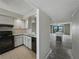 Small kitchen with white cabinets and black appliances adjacent to the living room at 7600 Sun Island S Dr # 603, South Pasadena, FL 33707