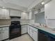 Small kitchen with white cabinets and black appliances; black range, sink, and dishwasher at 7600 Sun Island S Dr # 603, South Pasadena, FL 33707